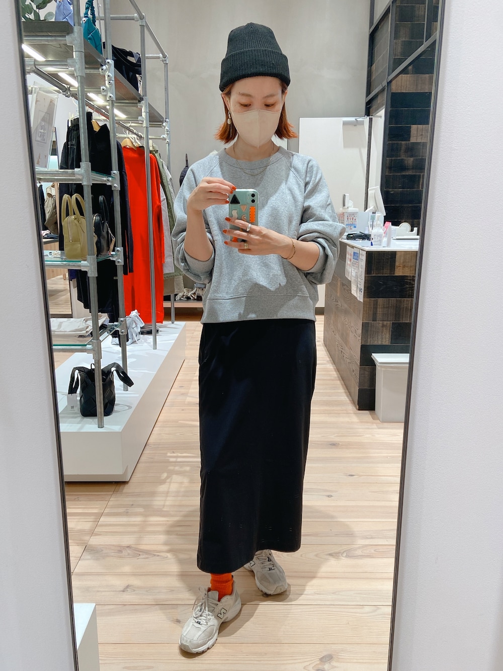 ブラック系のスカート、ホワイト系のシューズ、グレー系のスウェットを着用したレディースの秋コーディネートの1枚目の写真