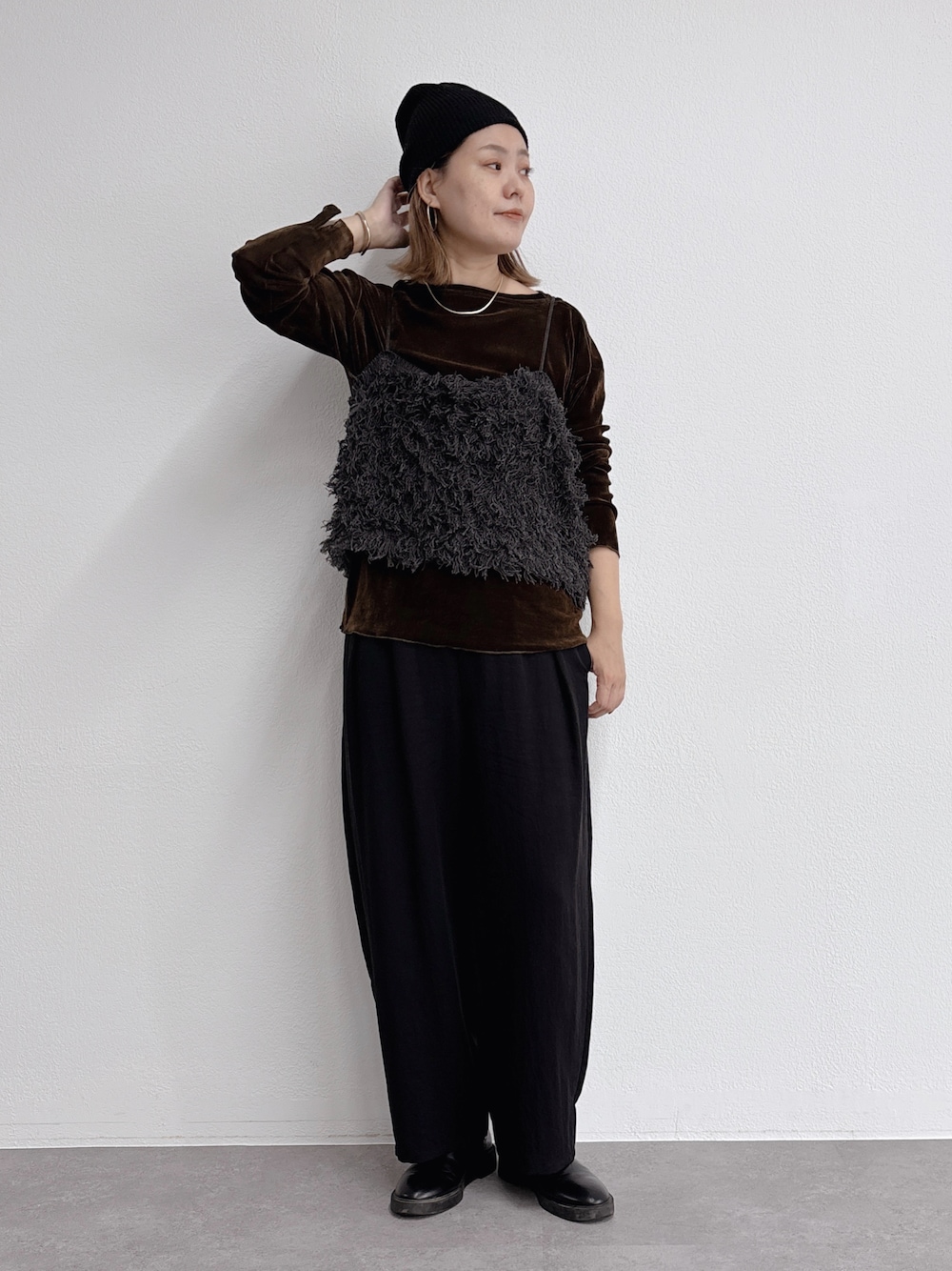 グレー系のニット/セーター、ブラウン系のTシャツ/カットソーを着用したレディースの秋コーディネートの1枚目の写真