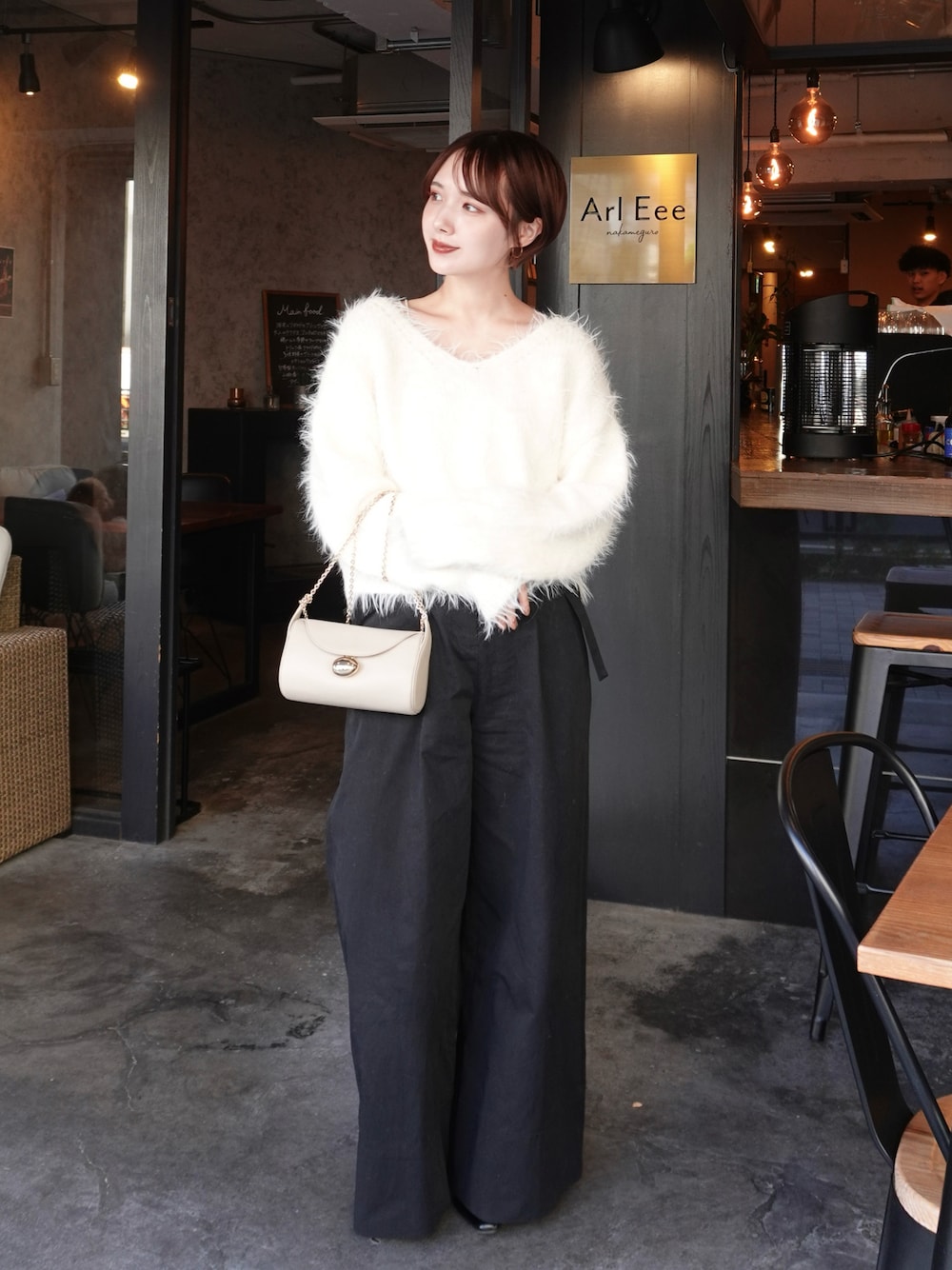 ホワイト系のニット/セーター、ブラック系のその他パンツ、ホワイト系のショルダーバッグを着用したレディースの冬コーディネートの1枚目の写真