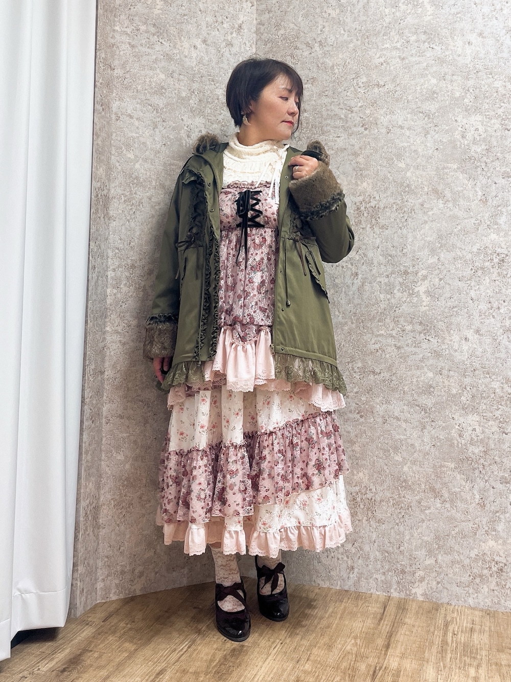 ピンク系のチュニック、ピンク系のスカート、レッド系のパンプスを着用したレディースの秋コーディネートの1枚目の写真