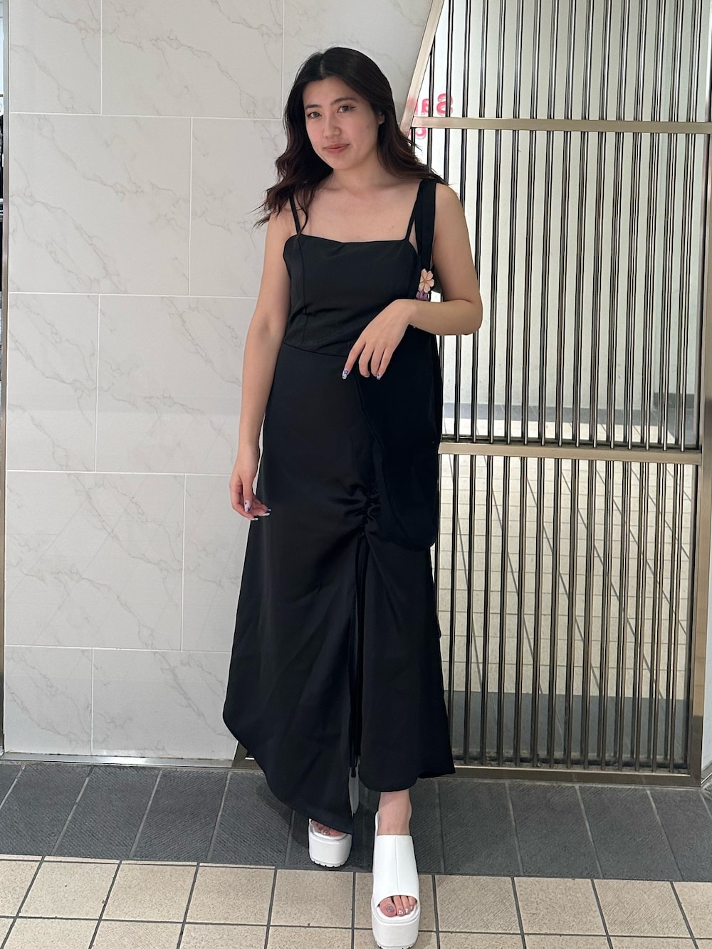 ブラック系のワンピース、ブラック系のトートバッグ、ホワイト系のサンダルを着用したレディースの夏コーディネートの1枚目の写真