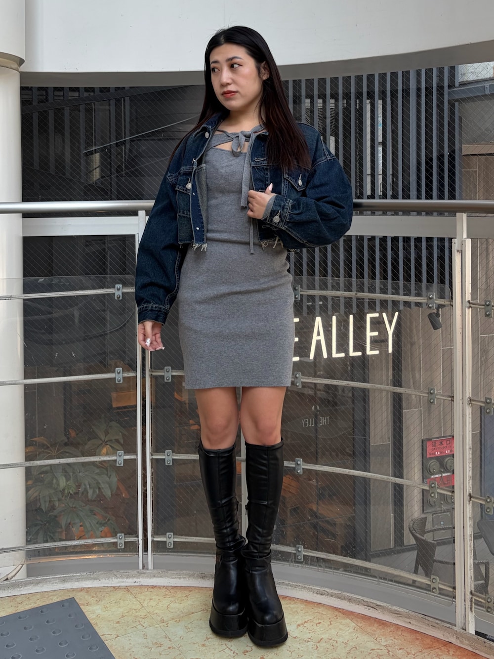 ブラック系のブーツ、ブルー系のデニムジャケット、グレー系のワンピースを着用したレディースの冬コーディネートの1枚目の写真