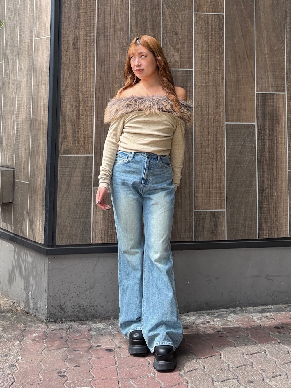 ブルー系のデニムパンツ、ベージュ系のTシャツ/カットソー、ブラック系のブーツを着用したレディースの秋コーディネートの1枚目の写真