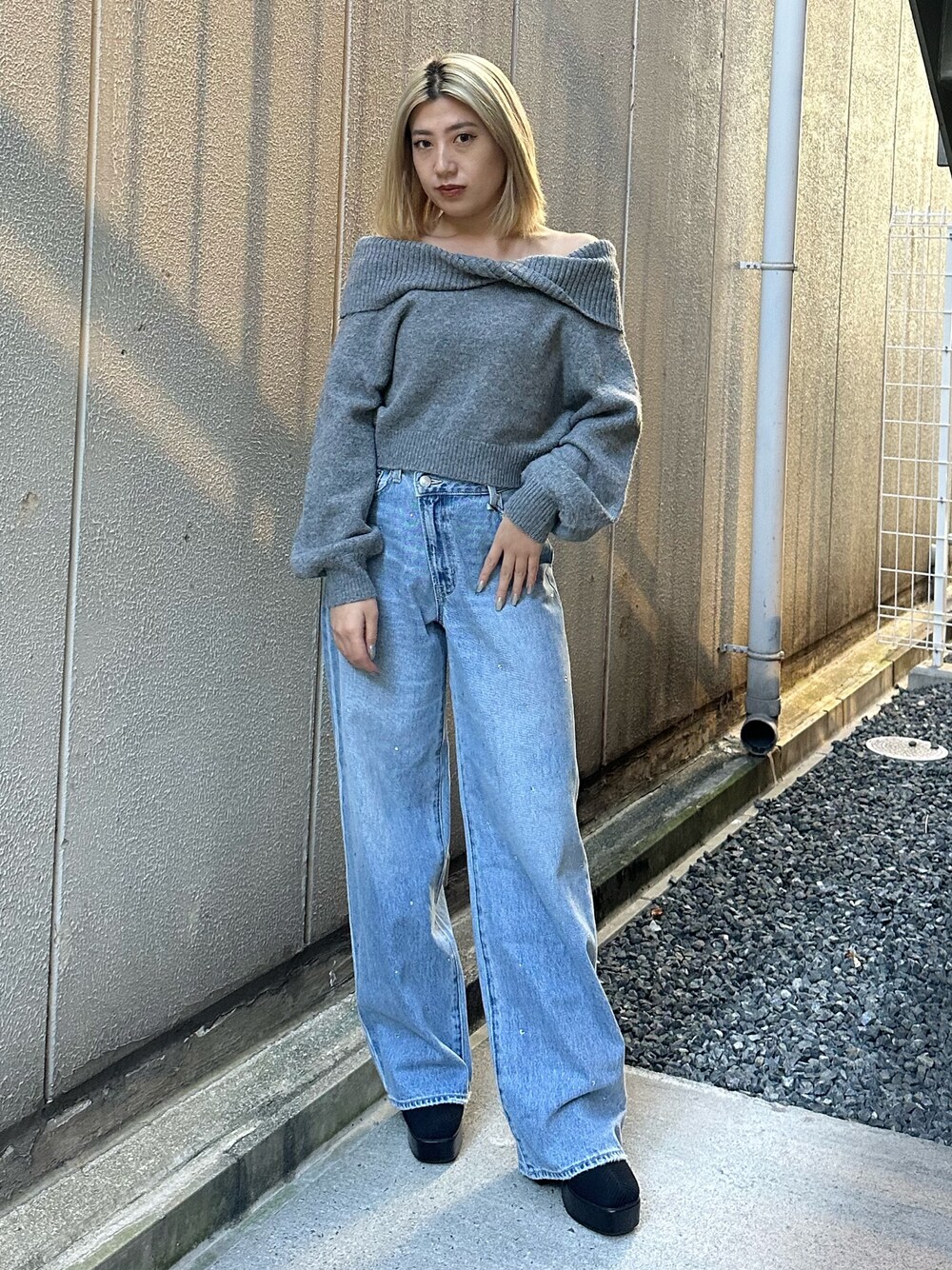 ブルー系のデニムパンツ、グレー系のニット/セーター、その他のブーツを着用したレディースの秋コーディネートの1枚目の写真