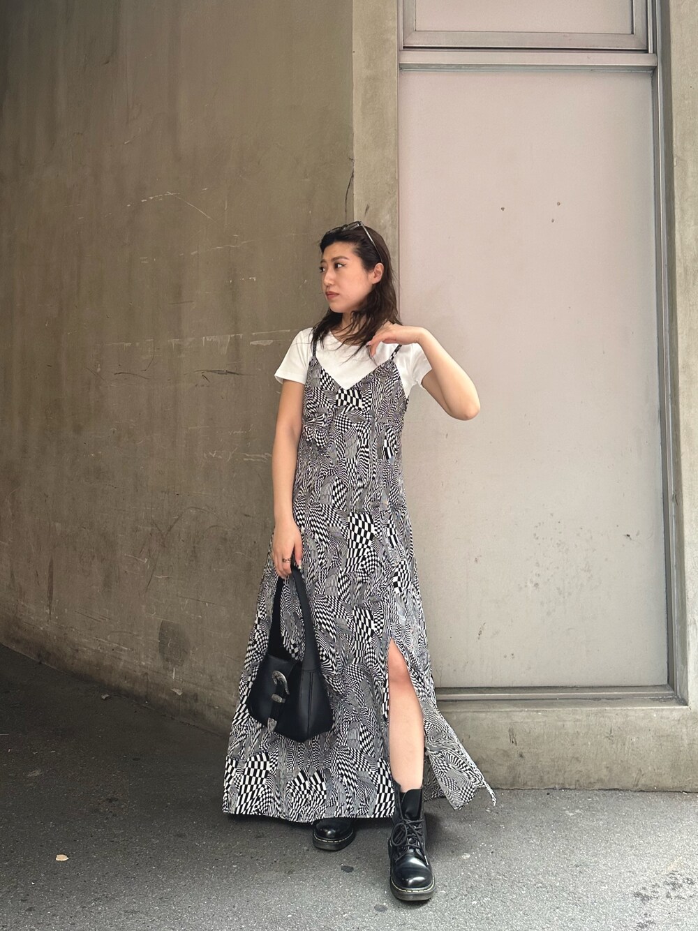 ブラック系のワンピース、ホワイト系のTシャツ/カットソー、ブラック系のハンドバッグを着用したレディースの春コーディネートの1枚目の写真