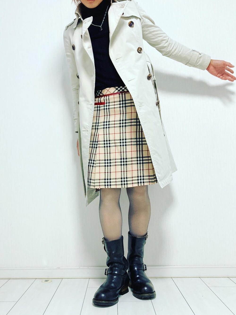 ベージュ系のスカート、ブラック系のブーツ、ブラック系のニット/セーターを着用したレディースの冬コーディネートの1枚目の写真