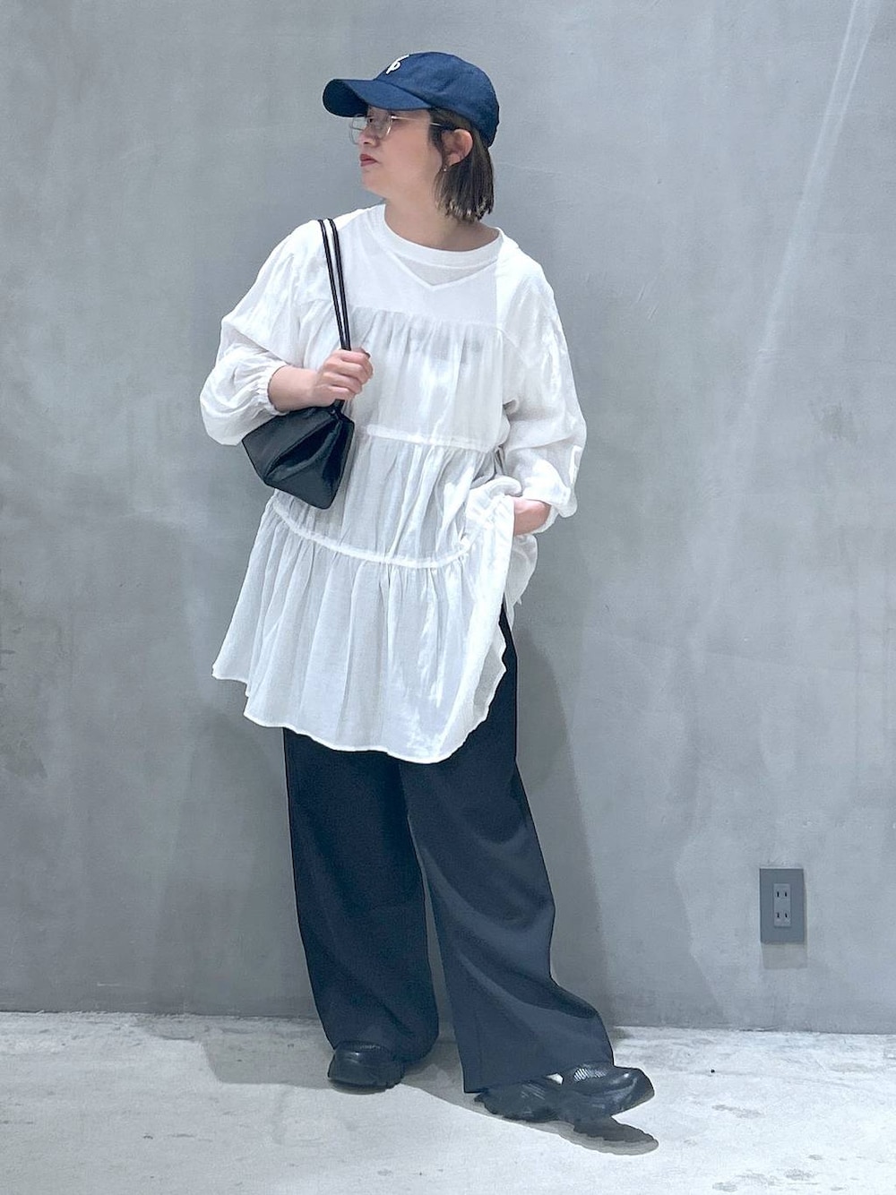 ブラック系のトートバッグ、ブラック系のスニーカー、ブラック系のその他パンツを着用したレディースの春コーディネートの1枚目の写真