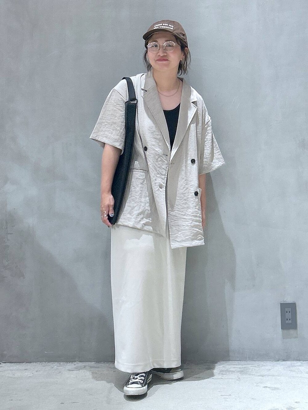 ブラック系のトートバッグ、ベージュ系のスカート、ベージュ系のテーラードジャケットを着用したレディースの夏コーディネートの1枚目の写真