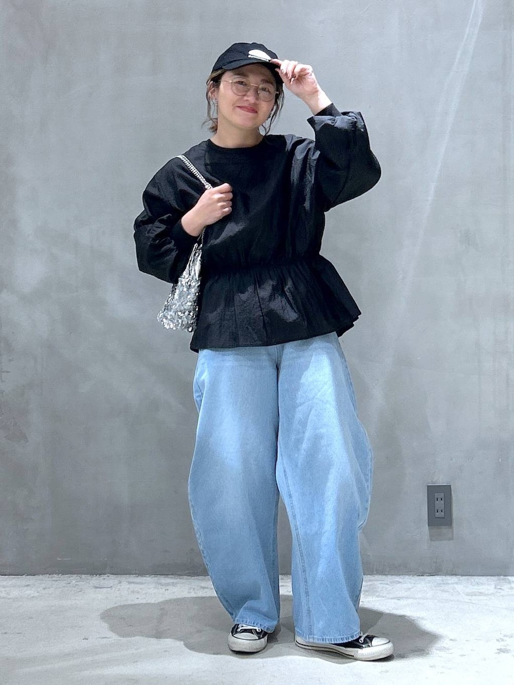 ブルー系のデニムパンツ、ブラック系のスウェット、その他のショルダーバッグを着用したレディースの冬コーディネートの1枚目の写真