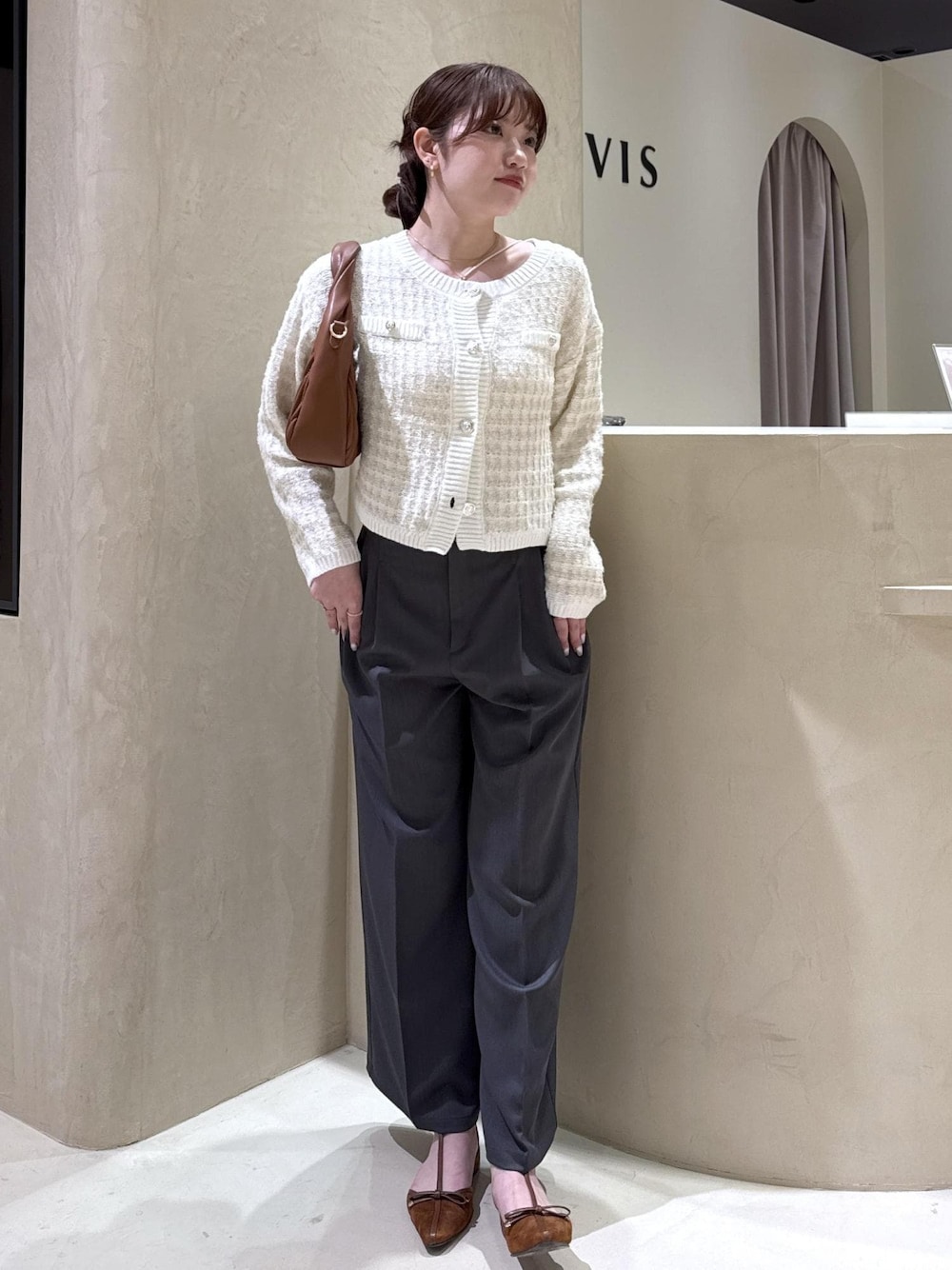 イエロー系のパンプス、ブラウン系のハンドバッグ、ホワイト系のカーディガン/ボレロを着用したレディースの秋コーディネートの1枚目の写真