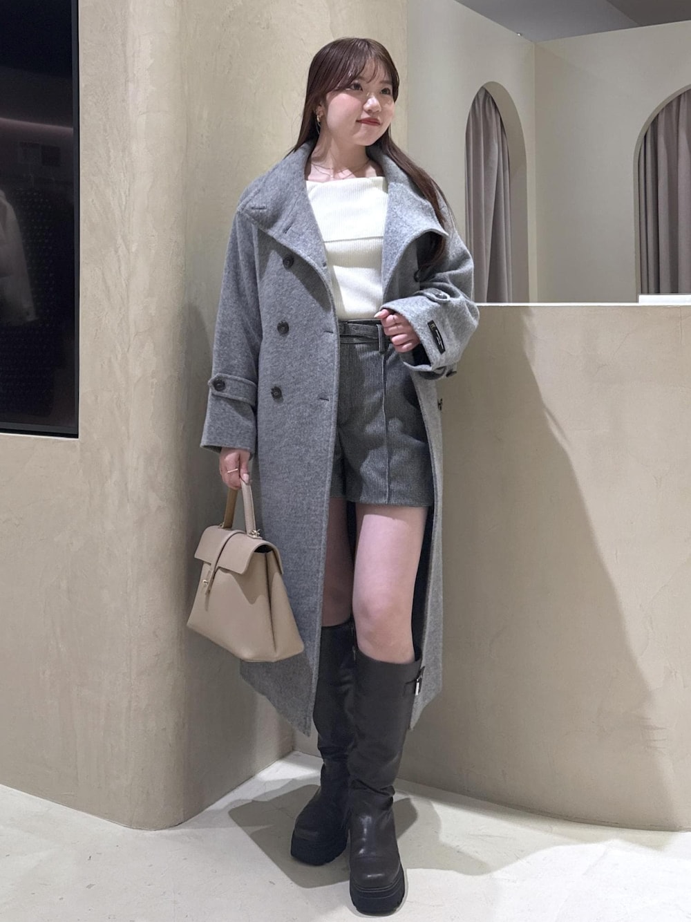 ベージュ系のハンドバッグ、ホワイト系のニット/セーター、グレー系のその他アウターを着用したレディースの秋コーディネートの1枚目の写真