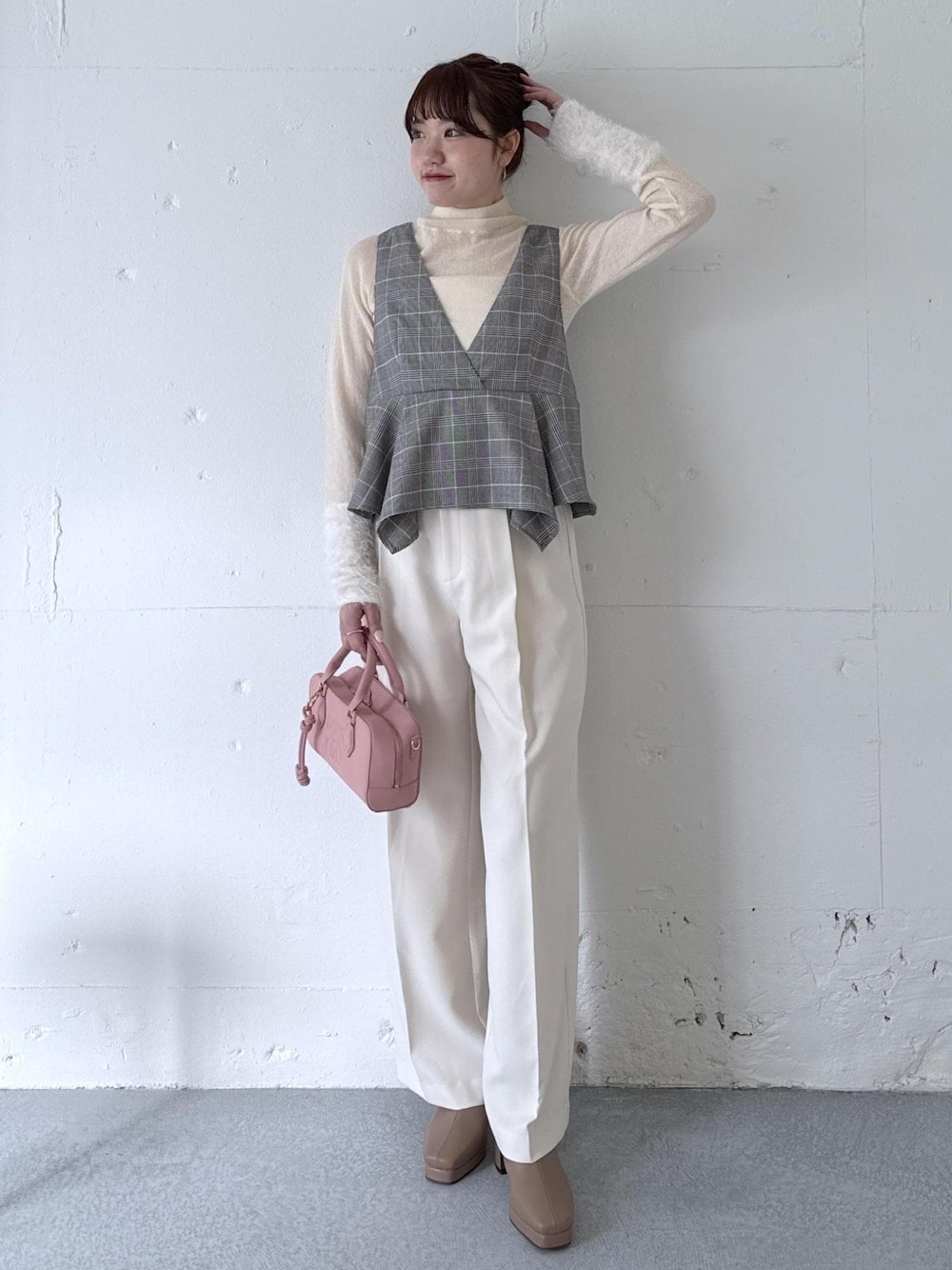ホワイト系のスラックス、ピンク系のボストンバッグ、ベージュ系のブーツを着用したレディースの秋コーディネートの1枚目の写真