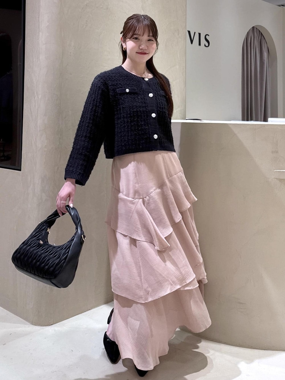 ホワイト系のキャミソール、ブラック系のパンプス、ブラック系のハンドバッグを着用したレディースの秋コーディネートの1枚目の写真