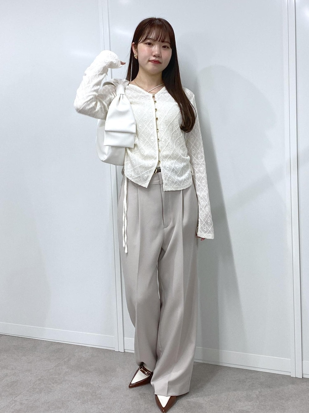 ブラウン系のパンプス、ホワイト系のキャミソール、ホワイト系のカーディガン/ボレロを着用したレディースの冬コーディネートの1枚目の写真