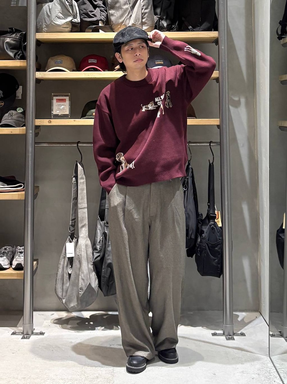 レッド系のニット/セーター、ベージュ系のその他パンツ、ブラック系のローファーを着用したメンズの秋コーディネートの1枚目の写真