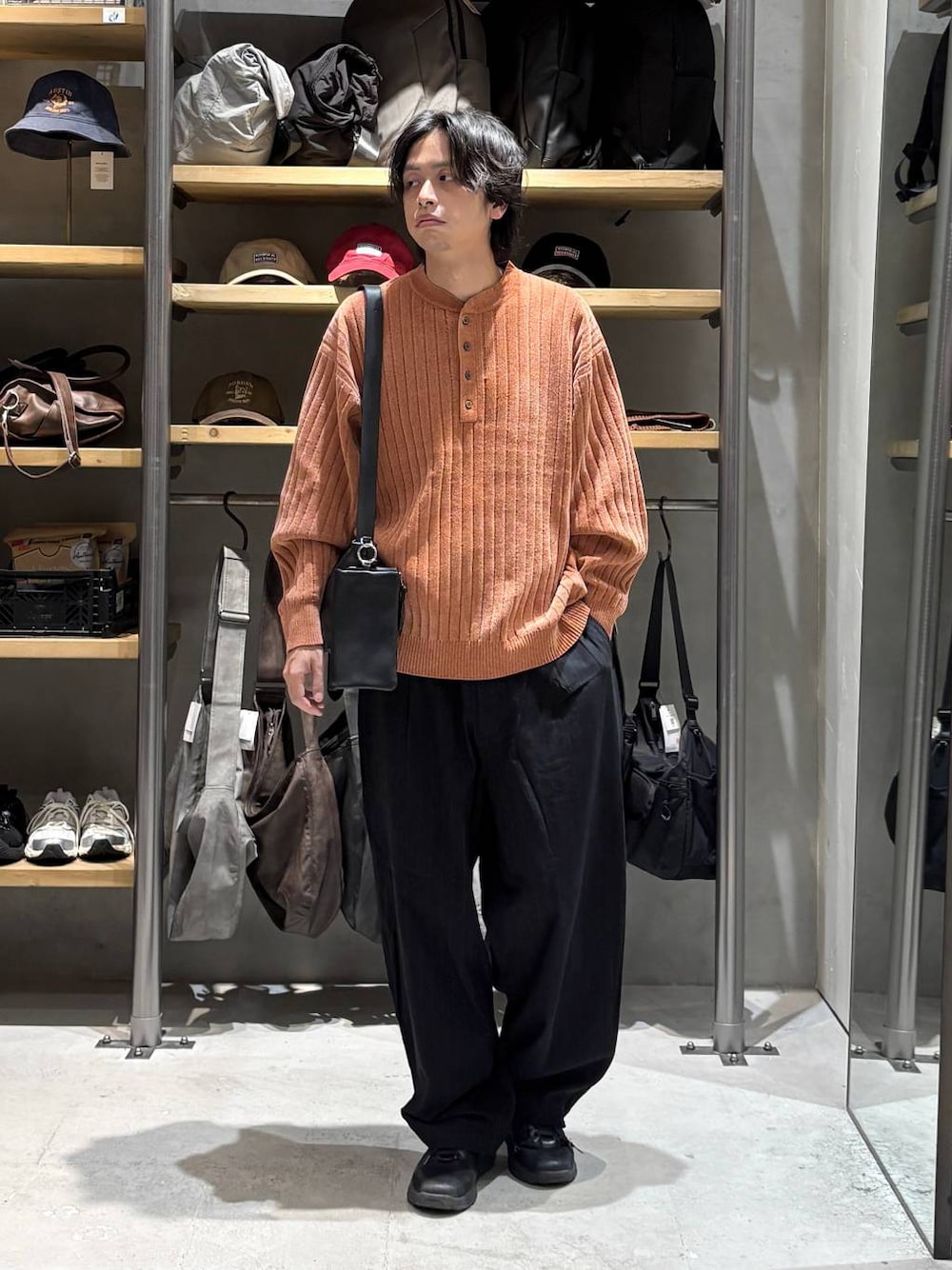 ブラック系のその他パンツ、オレンジ系のニット/セーターを着用したメンズの秋コーディネートの1枚目の写真