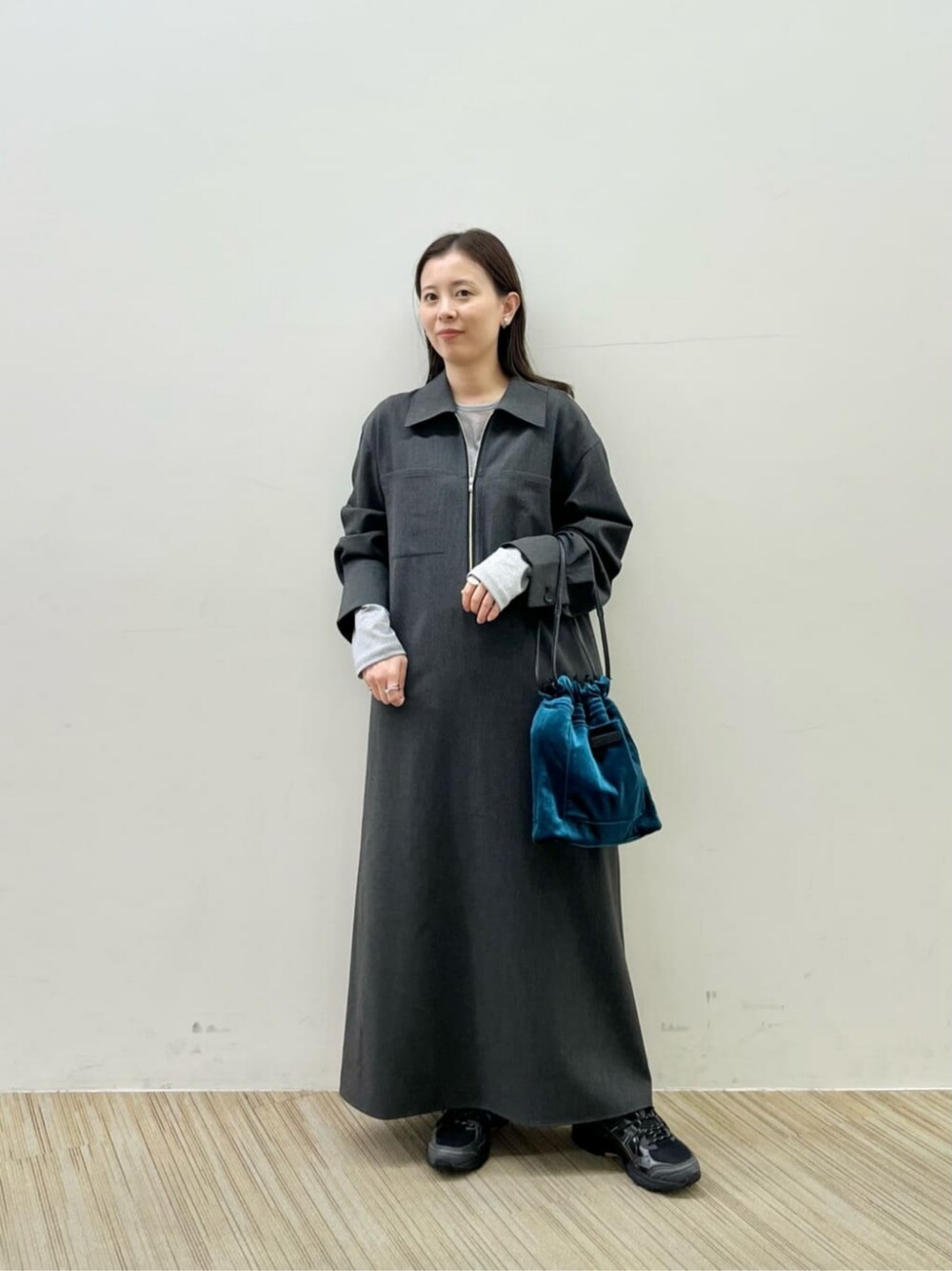 グレー系のワンピース、シルバー系のTシャツ/カットソー、ブラック系のショルダーバッグを着用したレディースの秋コーディネートの1枚目の写真