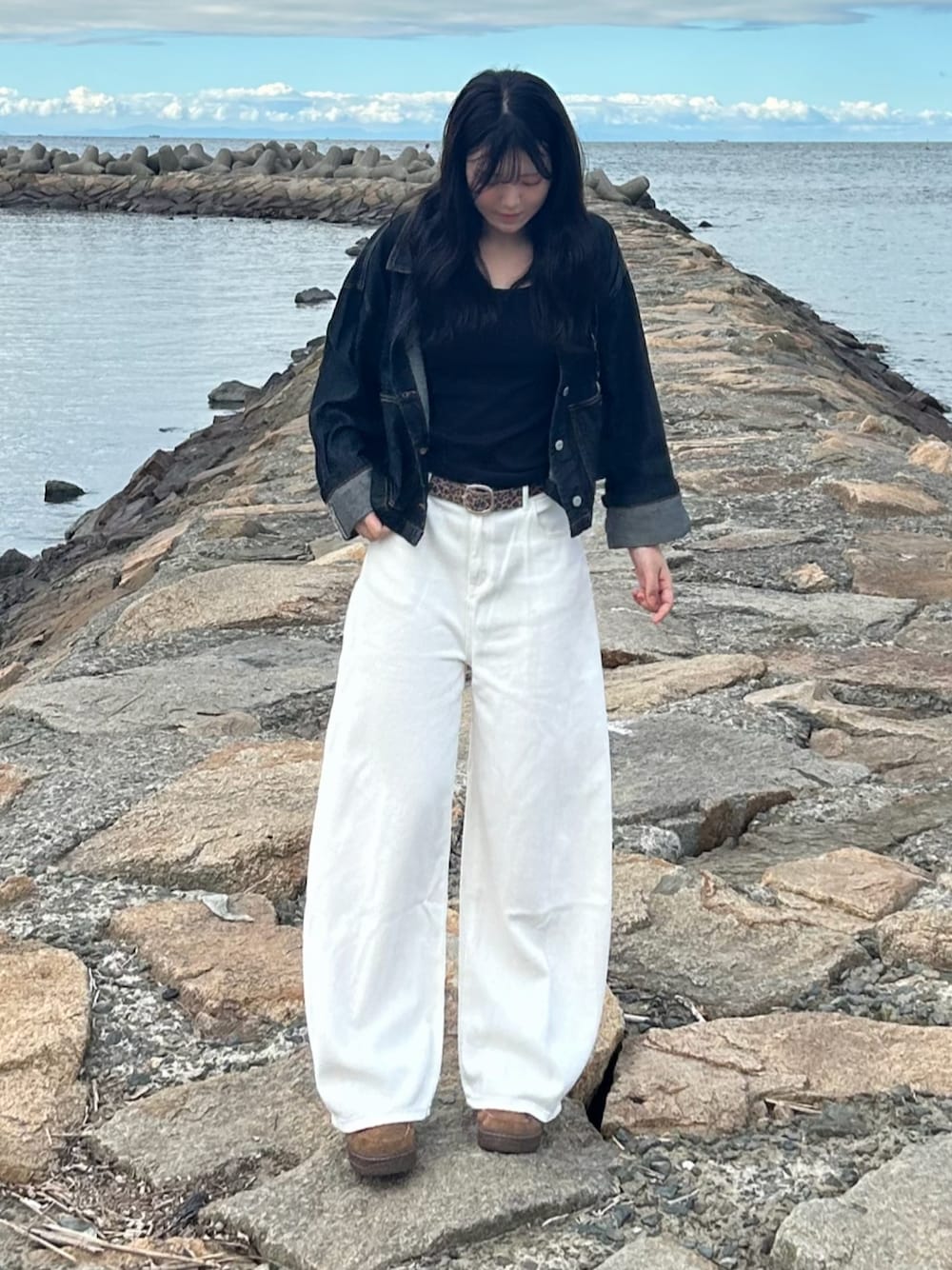 ブラウン系のスニーカー、ブラウン系のベルトを着用したレディースの秋コーディネートの1枚目の写真