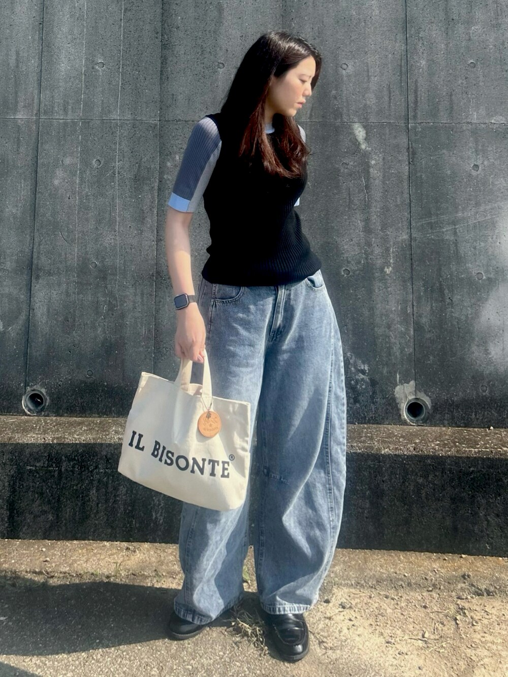 ブラック系のニット/セーター、ブラック系のローファー、ホワイト系のバッグを着用したレディースの夏コーディネートの1枚目の写真