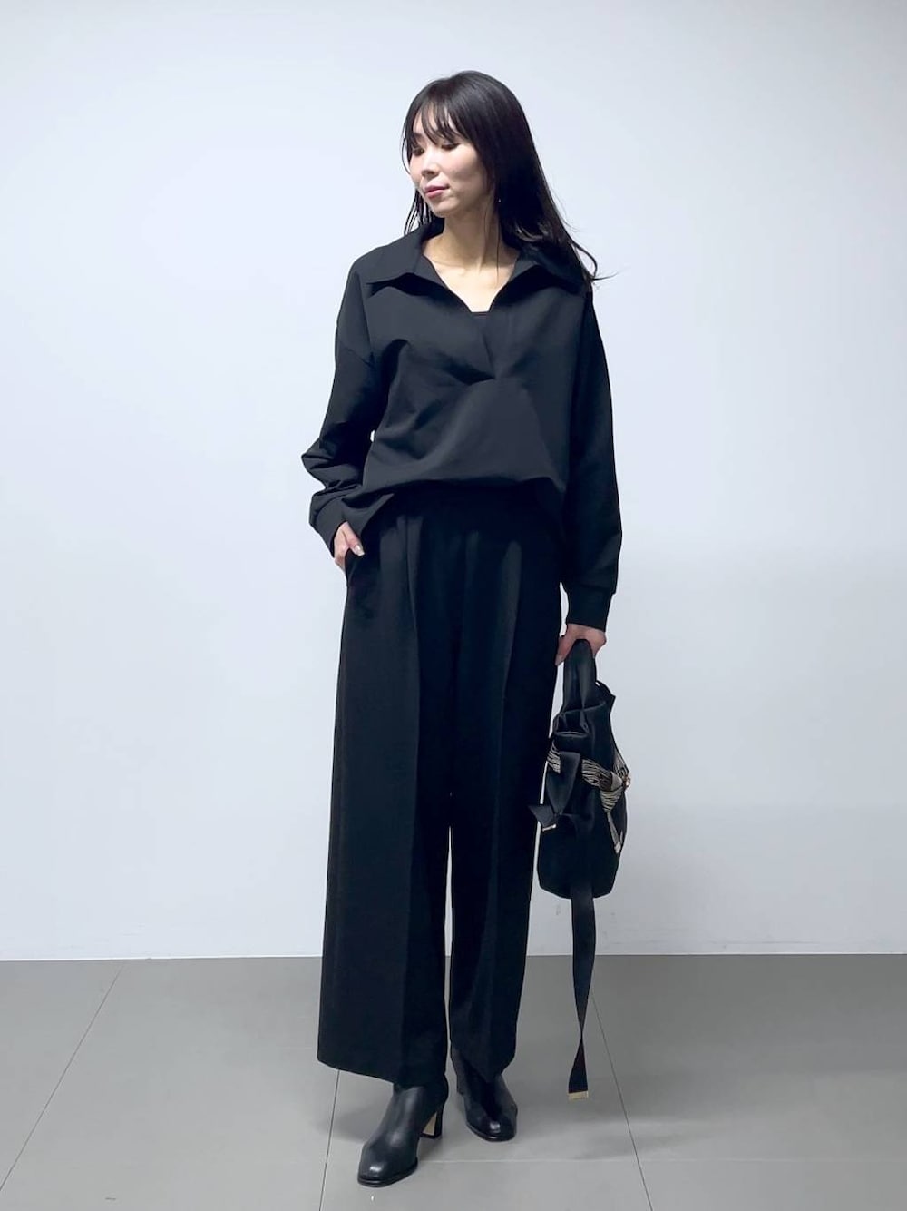 ブラック系のブーツ、ブラック系のシャツ/ブラウス、ブラック系のスラックスを着用したレディースの秋コーディネートの1枚目の写真