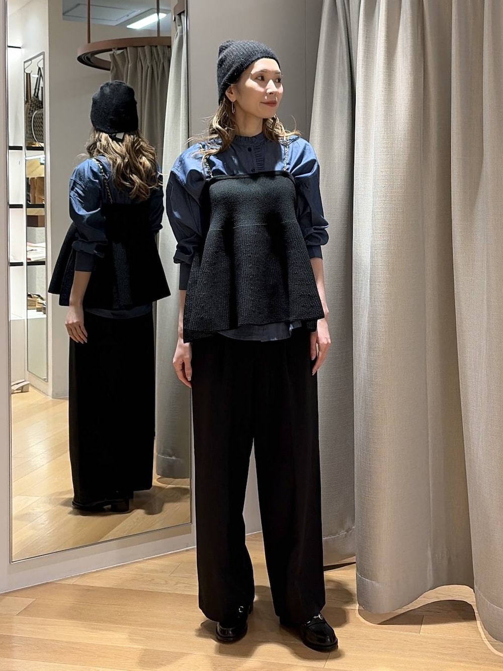 ブルー系のシャツ/ブラウス、ブラック系のニット/セーター、ブラック系のスラックスを着用したレディースの秋コーディネートの1枚目の写真