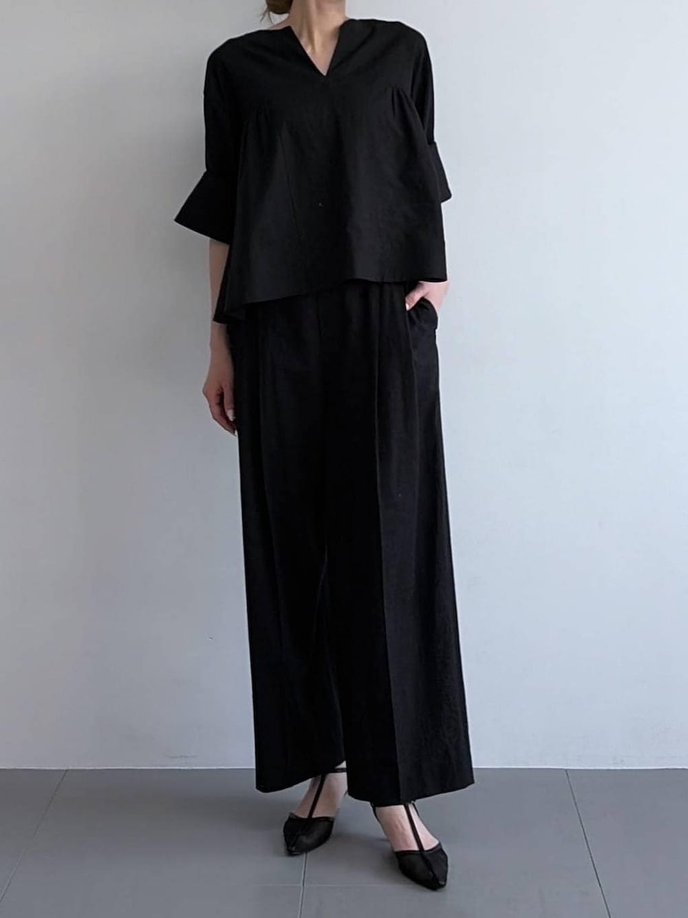 ブラック系のその他パンツ、ブラック系のシャツ/ブラウス、ブラック系のパンプスを着用したレディースの冬コーディネートの1枚目の写真