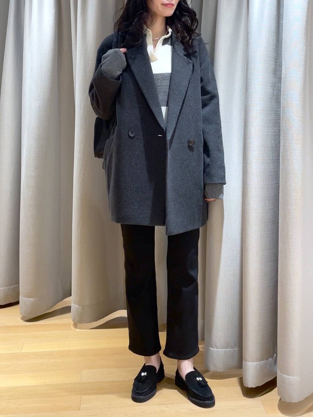 ホワイト系のニット/セーター、ブラック系のデニムパンツ、グレー系のピーコートを着用したレディースの秋コーディネートの1枚目の写真