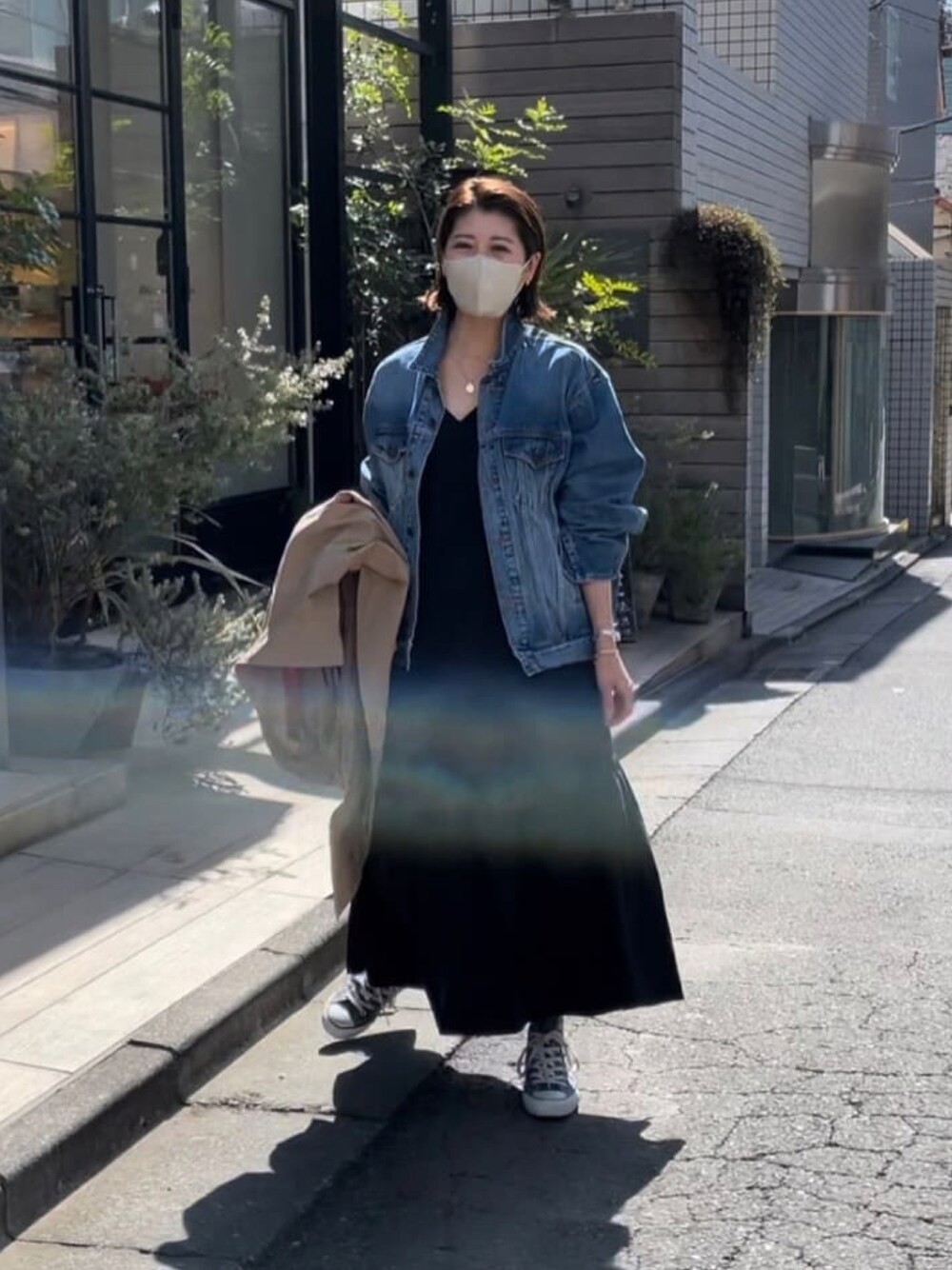 ブルー系のデニムジャケット、ブラック系のワンピース、グリーン系のモッズコートを着用したレディースの春コーディネートの1枚目の写真