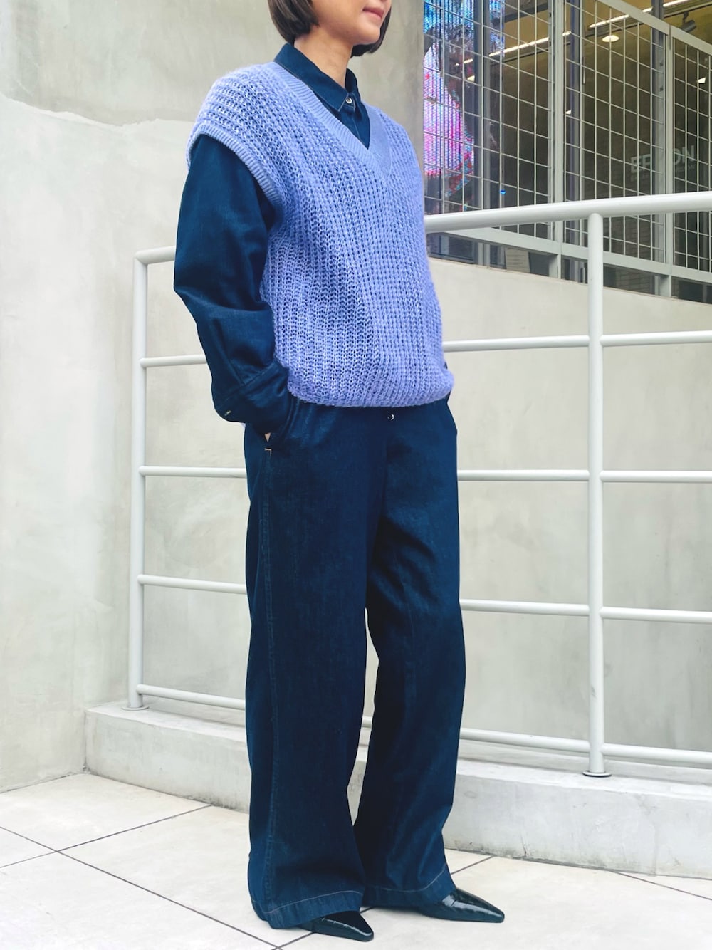 パープル系のベスト、ブルー系のシャツ/ブラウス、ブルー系のデニムパンツを着用したレディースの冬コーディネートの1枚目の写真