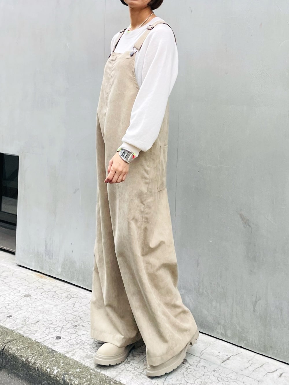 ベージュ系のサロペット/オーバーオール、ホワイト系のニット/セーターを着用したレディースの秋コーディネートの1枚目の写真