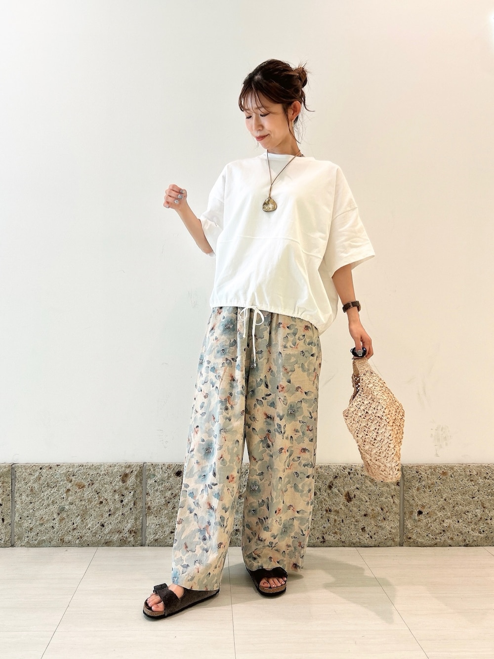 ホワイト系のTシャツ/カットソー、ベージュ系のハンドバッグ、ブルー系のその他パンツを着用したレディースの夏コーディネートの1枚目の写真