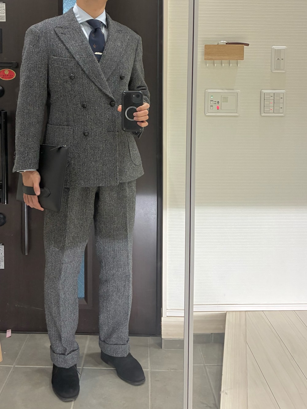 ブラック系のブーツ、ブルー系のシャツ/ブラウス、グレー系のスラックスを着用したメンズの冬コーディネートの1枚目の写真