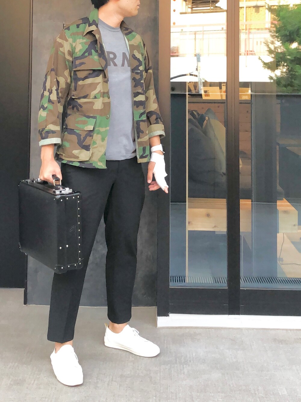 グレー系のTシャツ/カットソー、その他のミリタリージャケット、ブラック系のビジネスバッグを着用したメンズの秋コーディネートの1枚目の写真