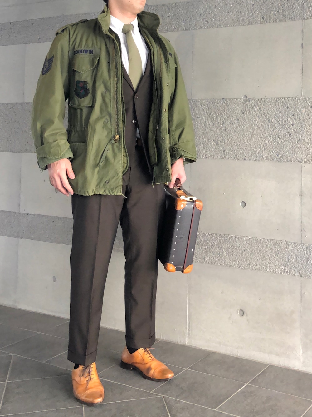 「M-65、M65、ミリタリー、ミリタリージャケット、スーツスタイル、ネクタイ、シャツ、スラックス、フォーマル、革靴、仕事着、古着、トラッド、きれいめ、オフィススタイル」｜「GLOBE-TROTTERのSafari 16（ビジネスバッグ、ブラウン系）」を使った、Chrisさん（メンズ・181cm）の冬コーディネートの1枚目の写真