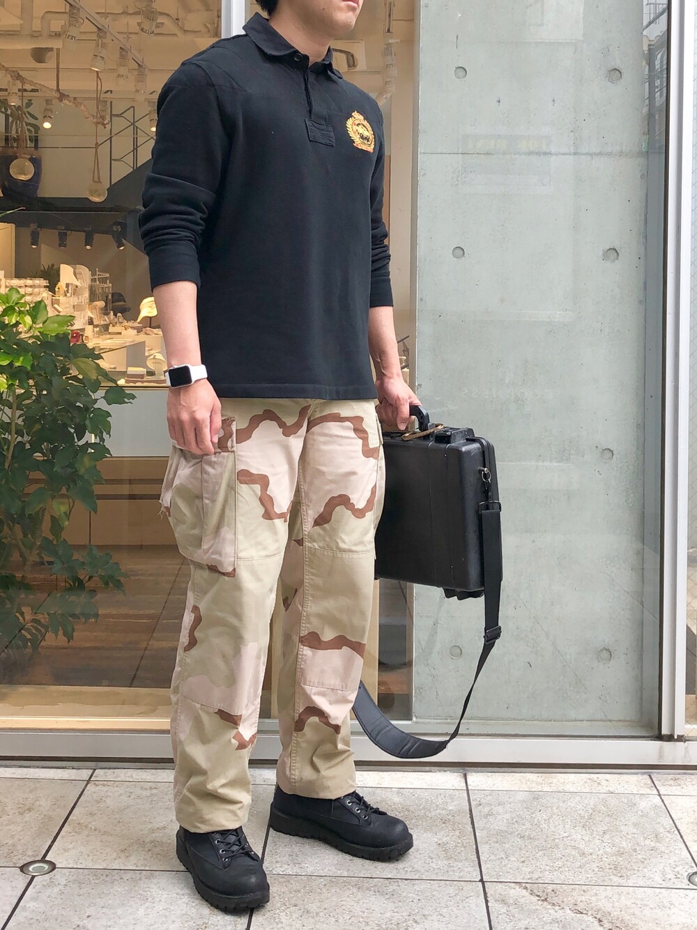 ベージュ系のカーゴパンツ、ブラック系のバッグ、ブラック系のブーツを着用したメンズの春コーディネートの1枚目の写真