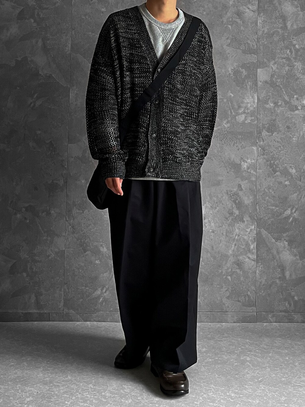 グレー系のカーディガン/ボレロ、ブラック系のパンツ、ブラック系のショルダーバッグを着用したメンズの春コーディネートの1枚目の写真