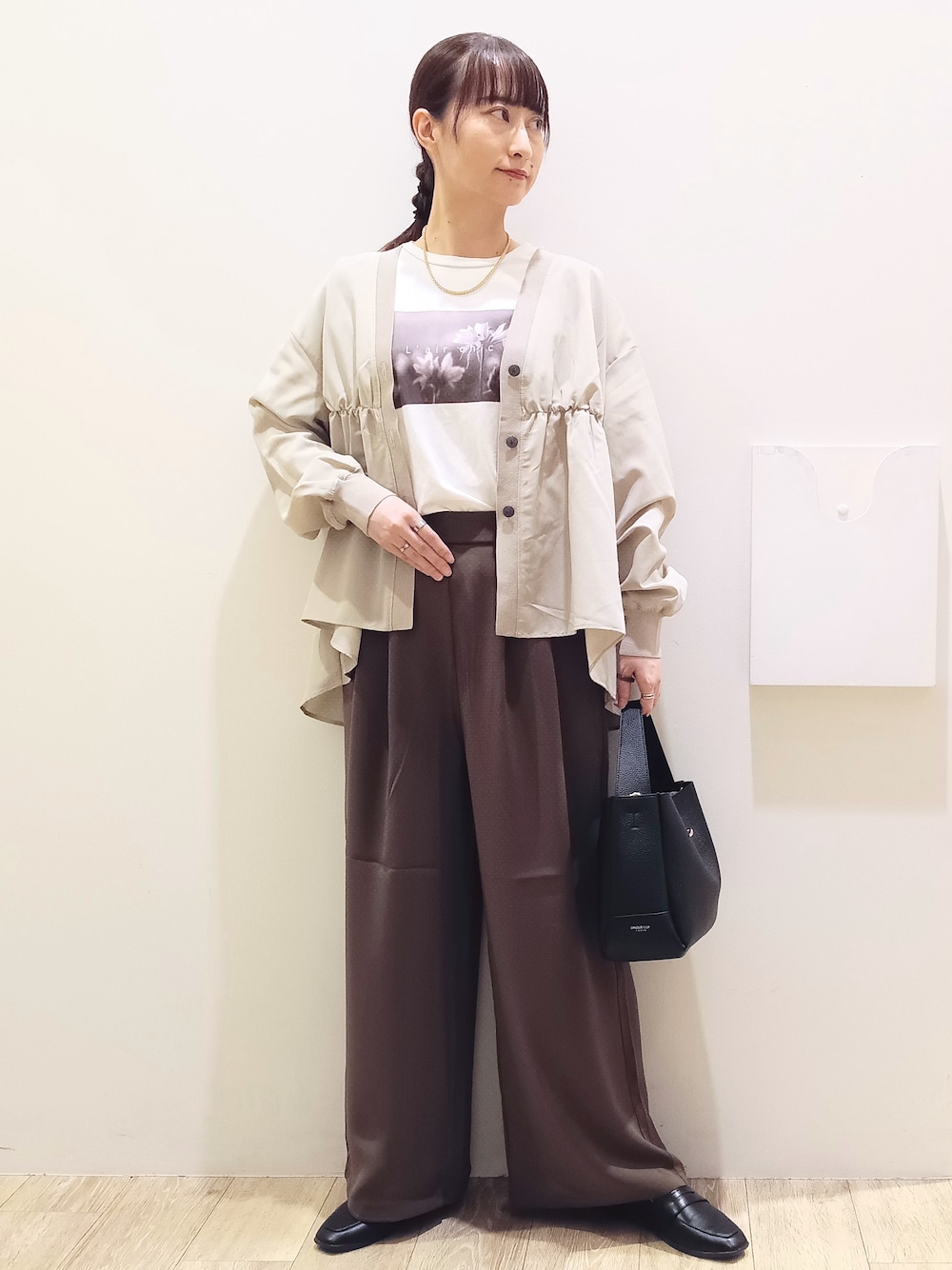 ホワイト系のTシャツ/カットソー、ベージュ系のカーディガン/ボレロ、ブラウン系のその他パンツを着用したレディースの秋コーディネートの1枚目の写真