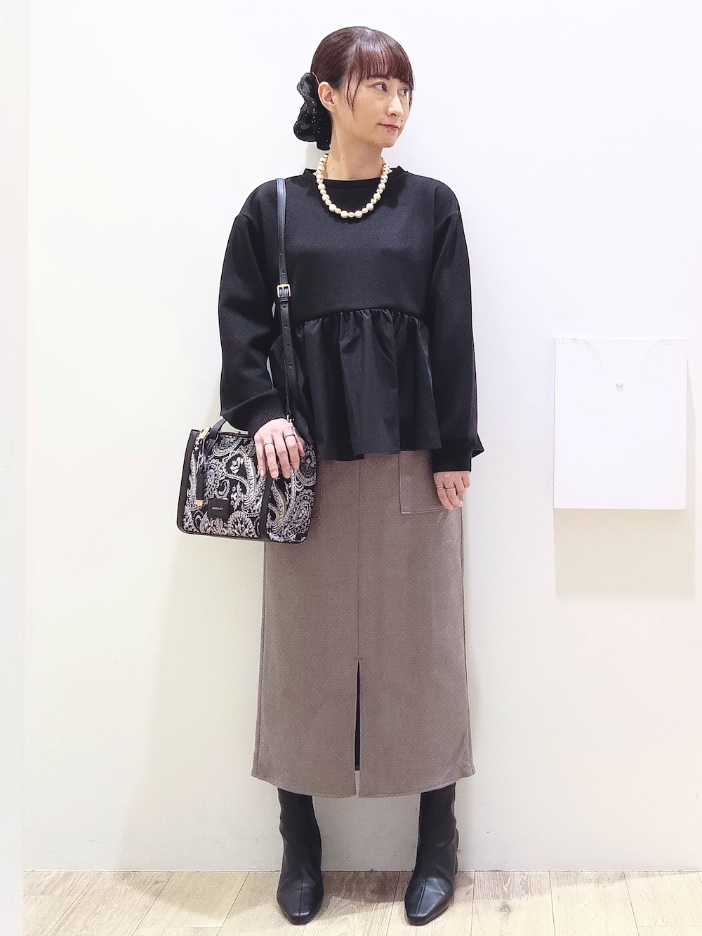 ブラック系のTシャツ/カットソー、ブラウン系のスカート、ブラック系のトートバッグを着用したレディースの秋コーディネートの1枚目の写真