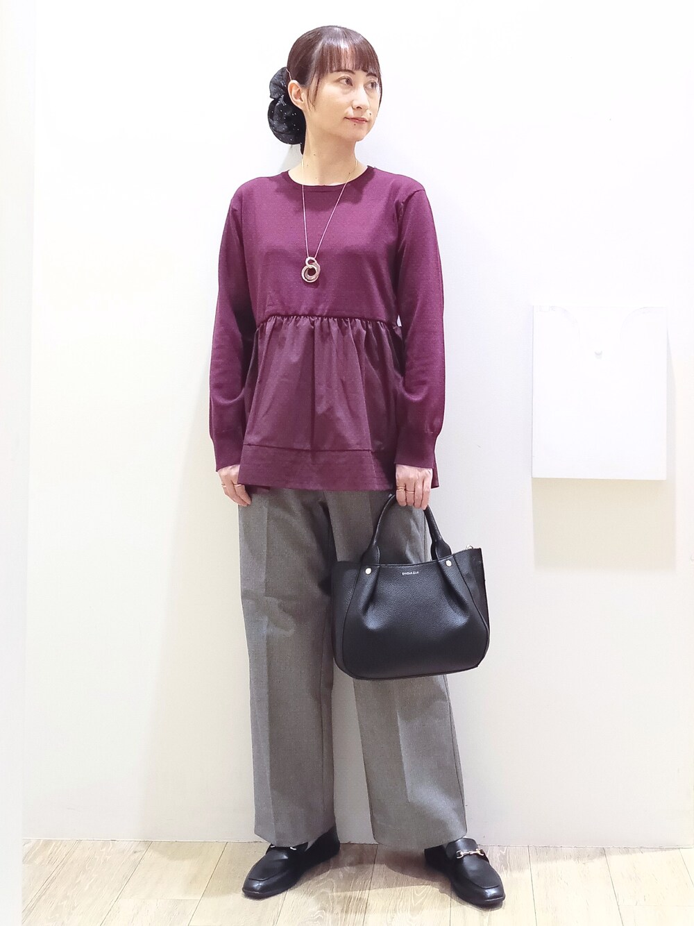 レッド系のニット/セーター、ブラック系のその他パンツ、ブラック系のトートバッグを着用したレディースの秋コーディネートの1枚目の写真