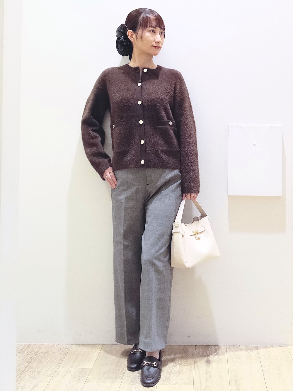 ブラウン系のカーディガン/ボレロ、ブラック系のその他パンツ、ホワイト系のトートバッグを着用したレディースの秋コーディネートの1枚目の写真