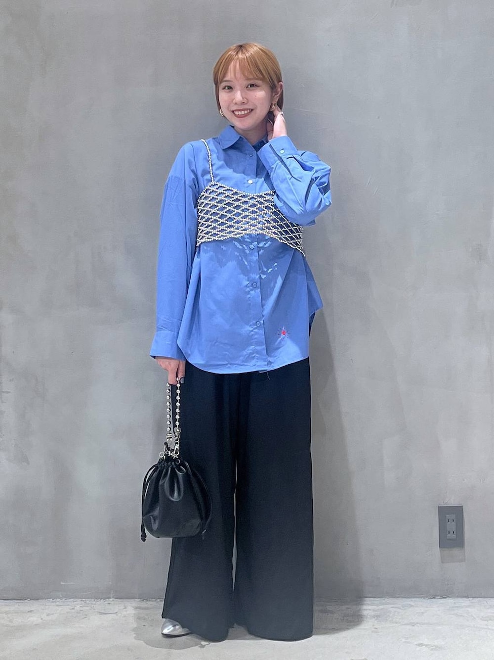 ブラック系のショルダーバッグ、シルバー系のパンプス、シルバー系のベストを着用したレディースの秋コーディネートの1枚目の写真