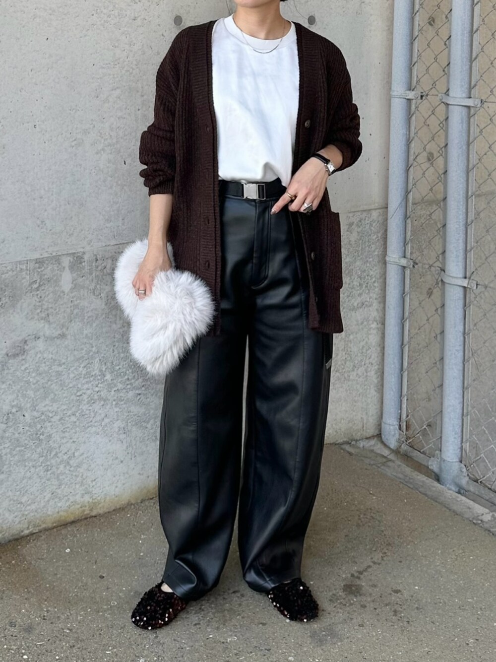 ブラック系のその他パンツ、ブラウン系のカーディガン/ボレロ、ホワイト系のハンドバッグを着用したレディースの秋コーディネートの1枚目の写真