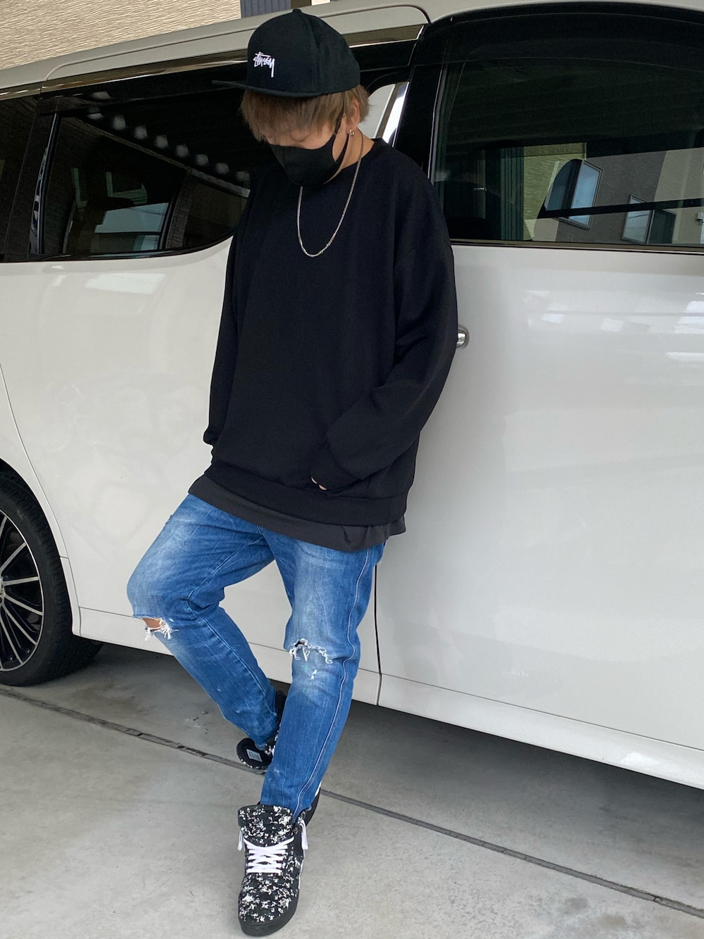 ブルー系のデニムパンツ、ブラック系のスニーカー、ブラック系のスウェットを着用したメンズの秋コーディネートの1枚目の写真