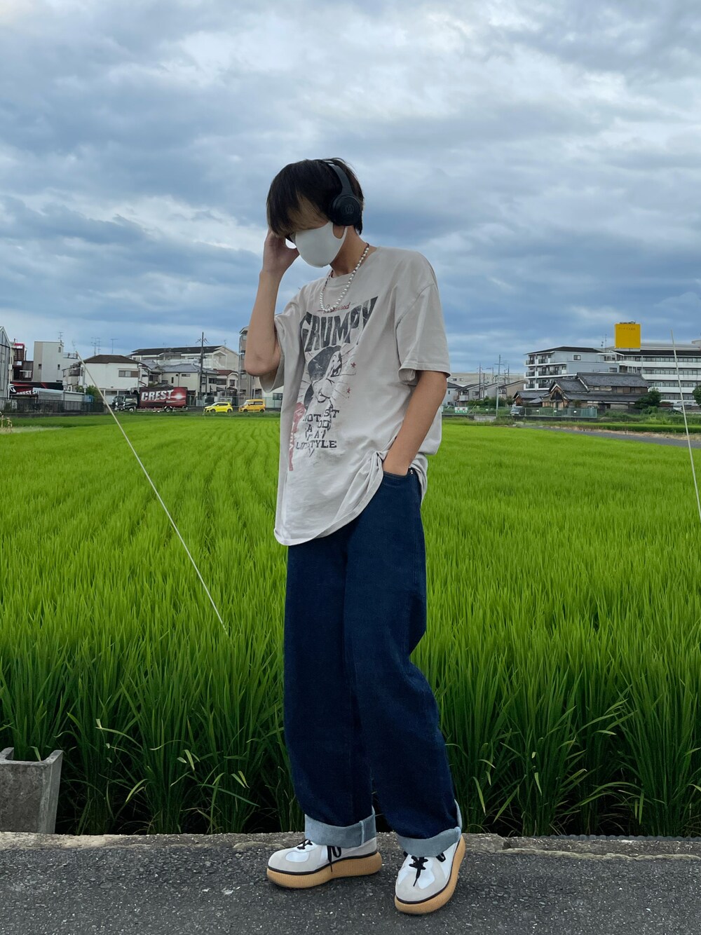 ブルー系のデニムパンツ、ホワイト系のTシャツ/カットソー、ホワイト系のスニーカーを着用したメンズの夏コーディネートの1枚目の写真