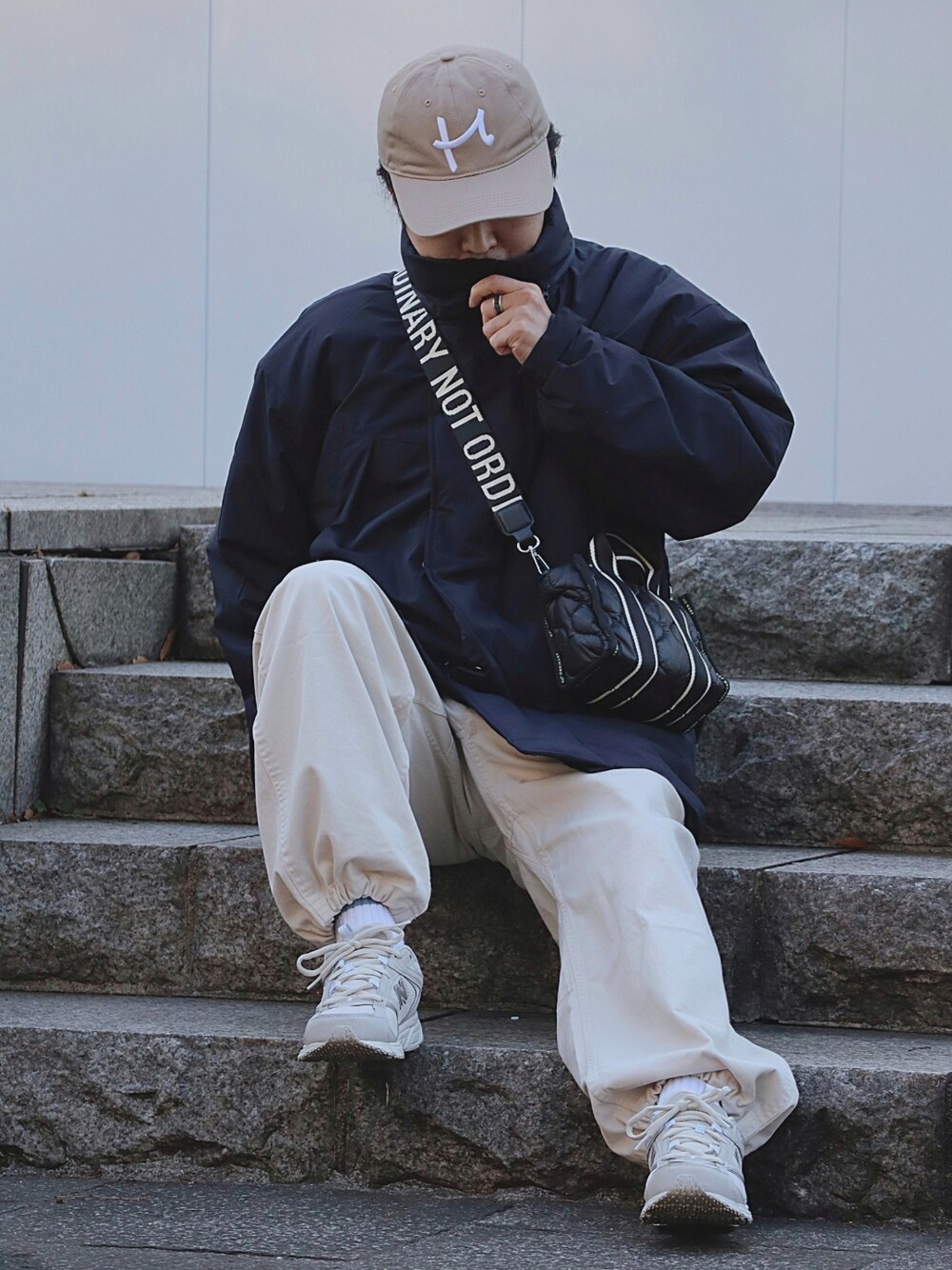 ベージュ系のその他パンツ、グレー系のスニーカー、ブラック系のトートバッグを着用したメンズの冬コーディネートの2枚目の写真