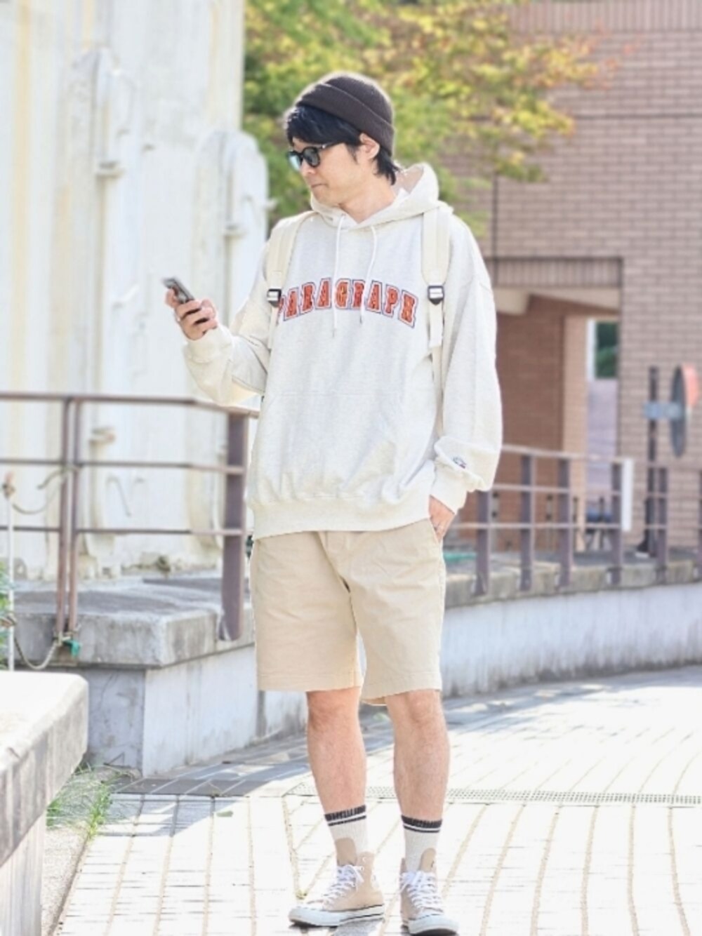 「秋コーデ、Paragraph、パーカー、ショートパンツ、ストリート、ハイカットスニーカー、リュック、韓国ファッション、韓国ブランド、韓国ストリート、ストリートMIX、ニット帽、ブラウン×ベージュ、コンバース、カレッジ」｜「ParagraphのA'GEM/9 × .kom『paragraph/パラグラフ』INDUSTRIAL EMBROIDERY HOOD/カレッジ アーチロゴ プルオーバーパーカー（パーカー、グレー系）」を使った、naokさん（メンズ・175cm）の秋コーディネートの1枚目の写真
