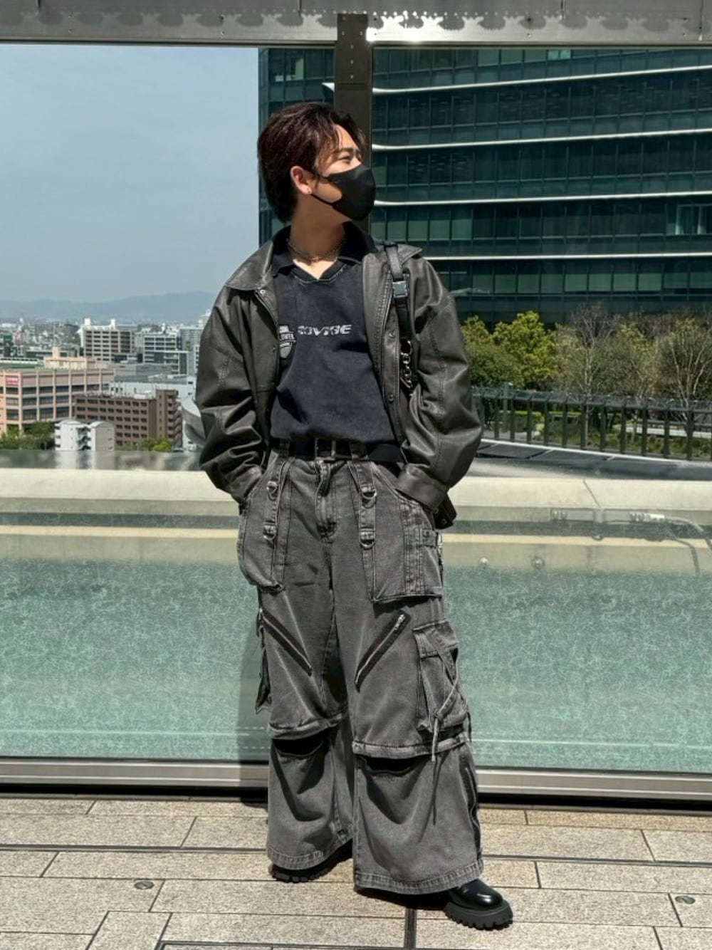 ブラック系のブルゾン、ブラック系のTシャツ/カットソー、ブラック系のカーゴパンツを着用したメンズの春コーディネートの1枚目の写真