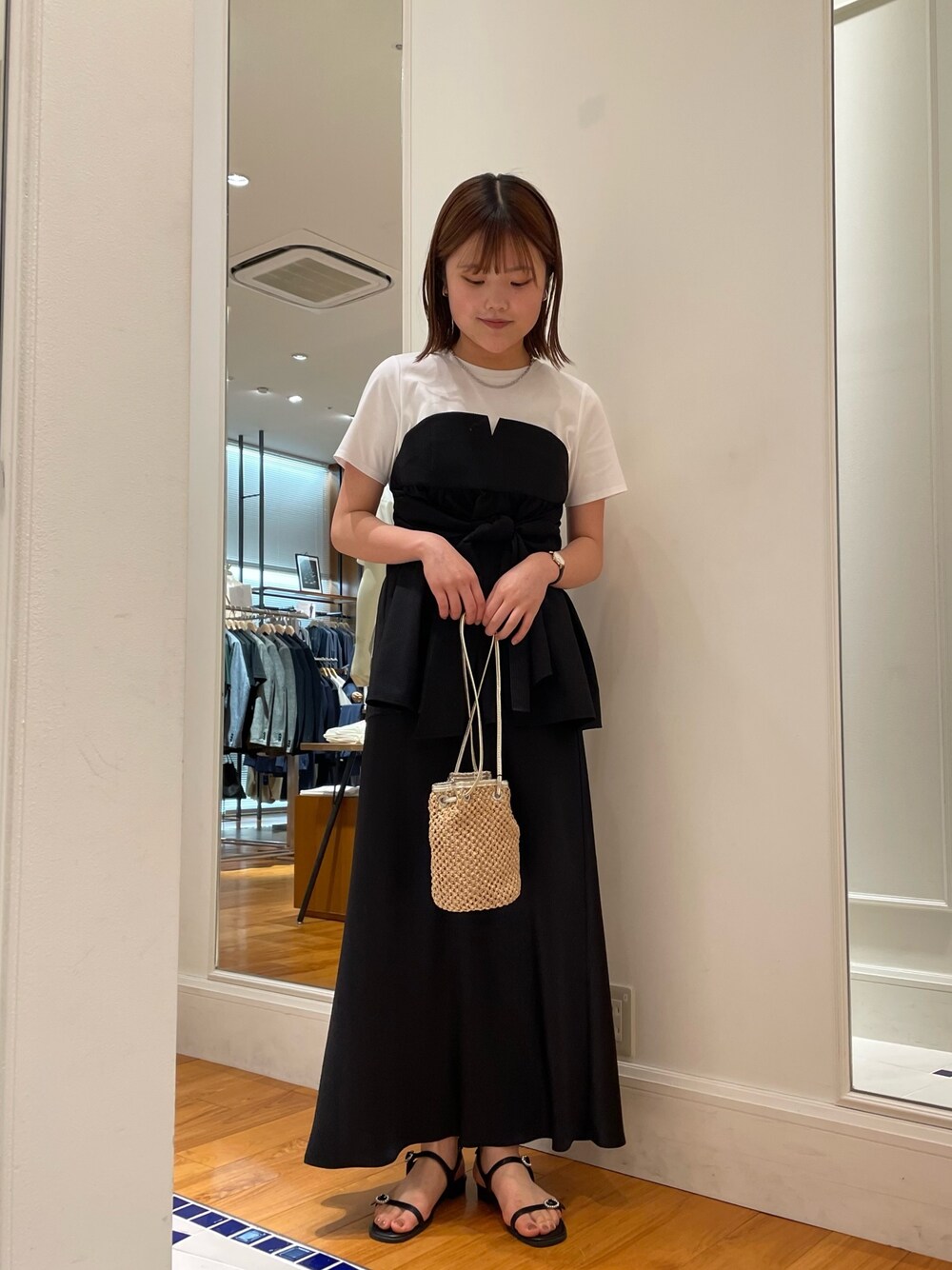 ブラック系のTシャツ/カットソー、ブラック系のスカート、ブラック系のサンダルを着用したレディースの春コーディネートの1枚目の写真