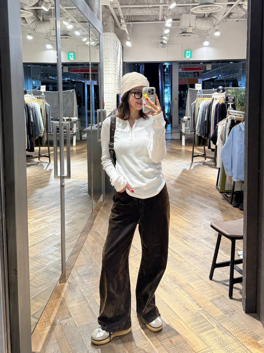 ブラウン系のショルダーバッグ、ホワイト系のTシャツ/カットソー、ブラウン系のデニムパンツを着用したレディースの秋コーディネートの1枚目の写真