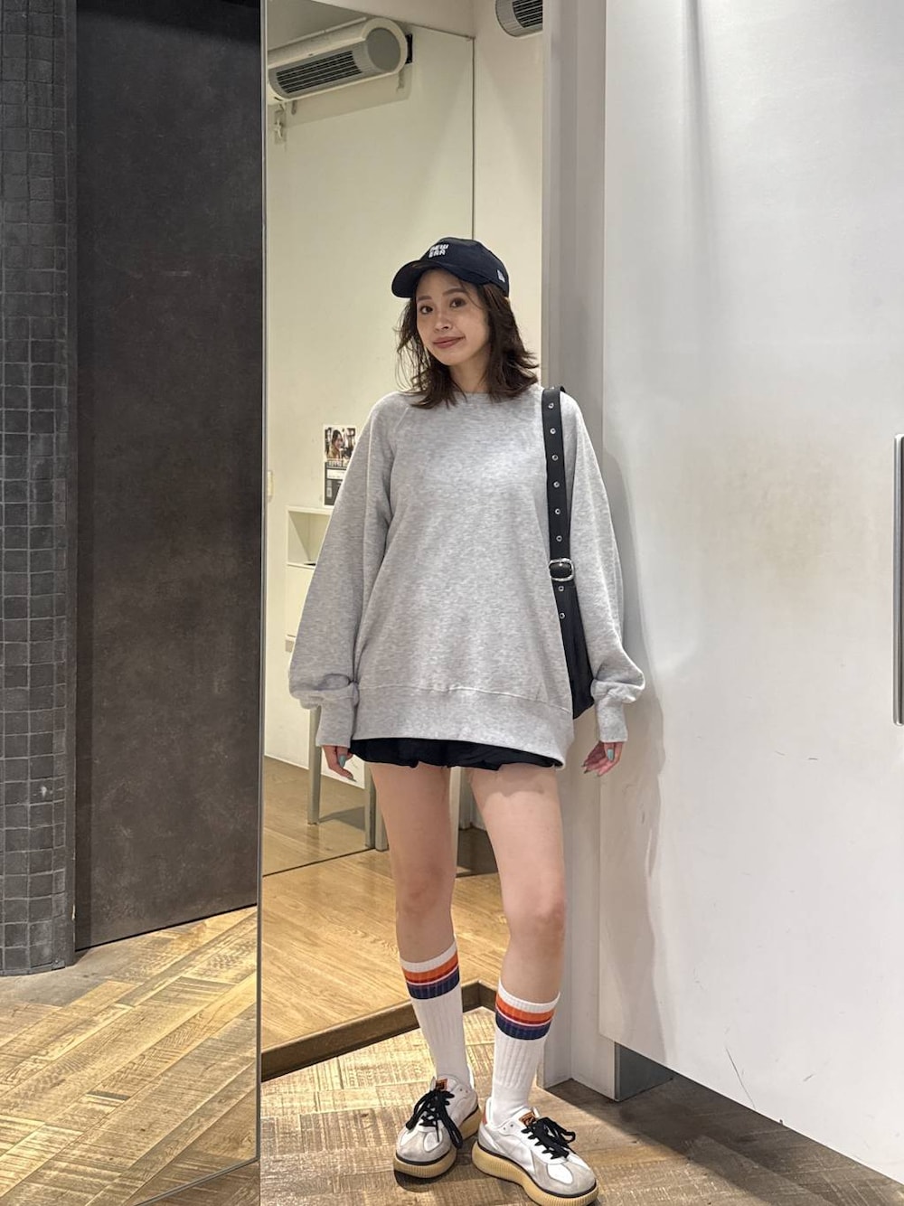 ブラック系のショルダーバッグ、ブラック系のその他パンツ、グレー系のスウェットを着用したレディースの秋コーディネートの1枚目の写真